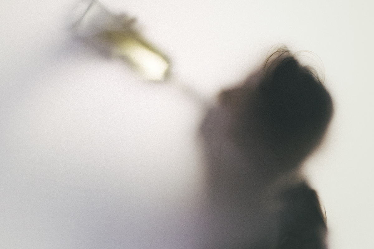 1 de 1 Foto colorida de sombra de silhueta humana segurando uma garrafa de bebida em direção a ...