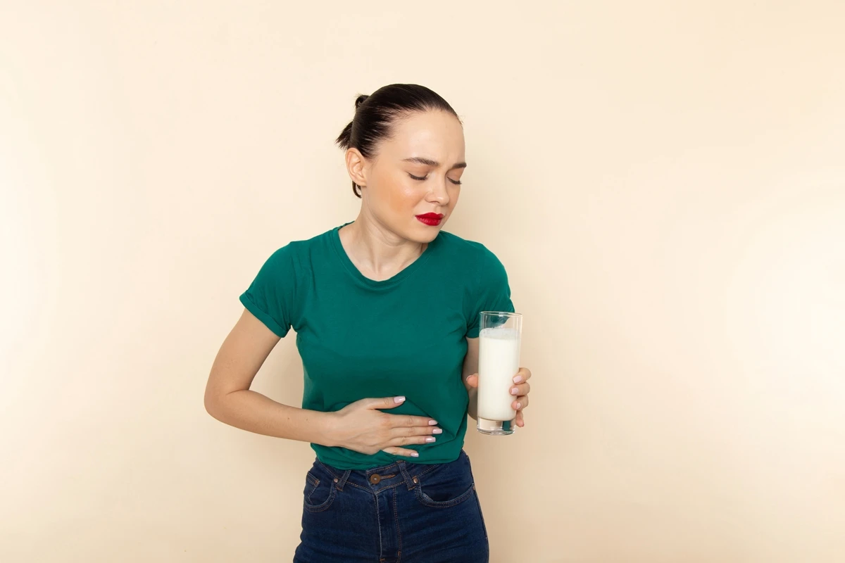 1 de 1 Mulher segurando um copo de leite e segurando a barriga- Metrópoles - Foto: Freepik