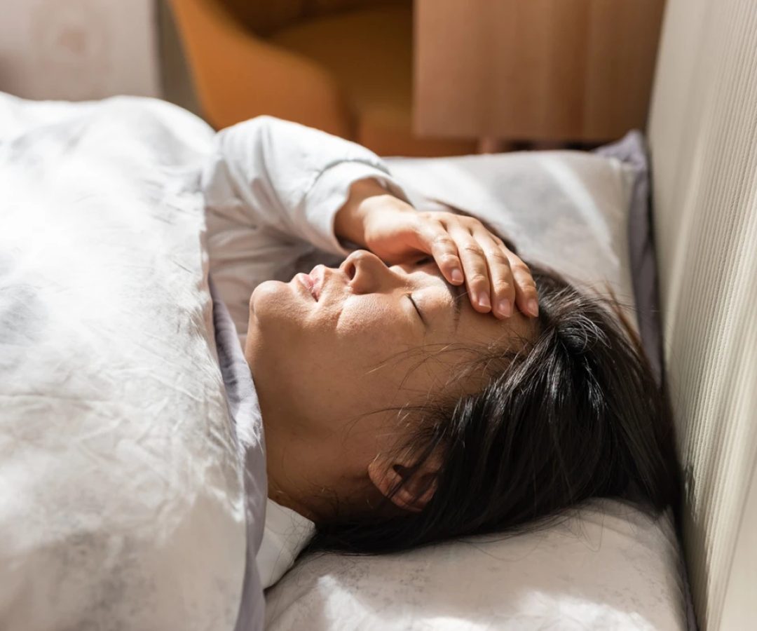 1 de 1 Jovem mulher asiática com a mão no rosto deitada em cama - Metrópoles - Foto: Getty Images