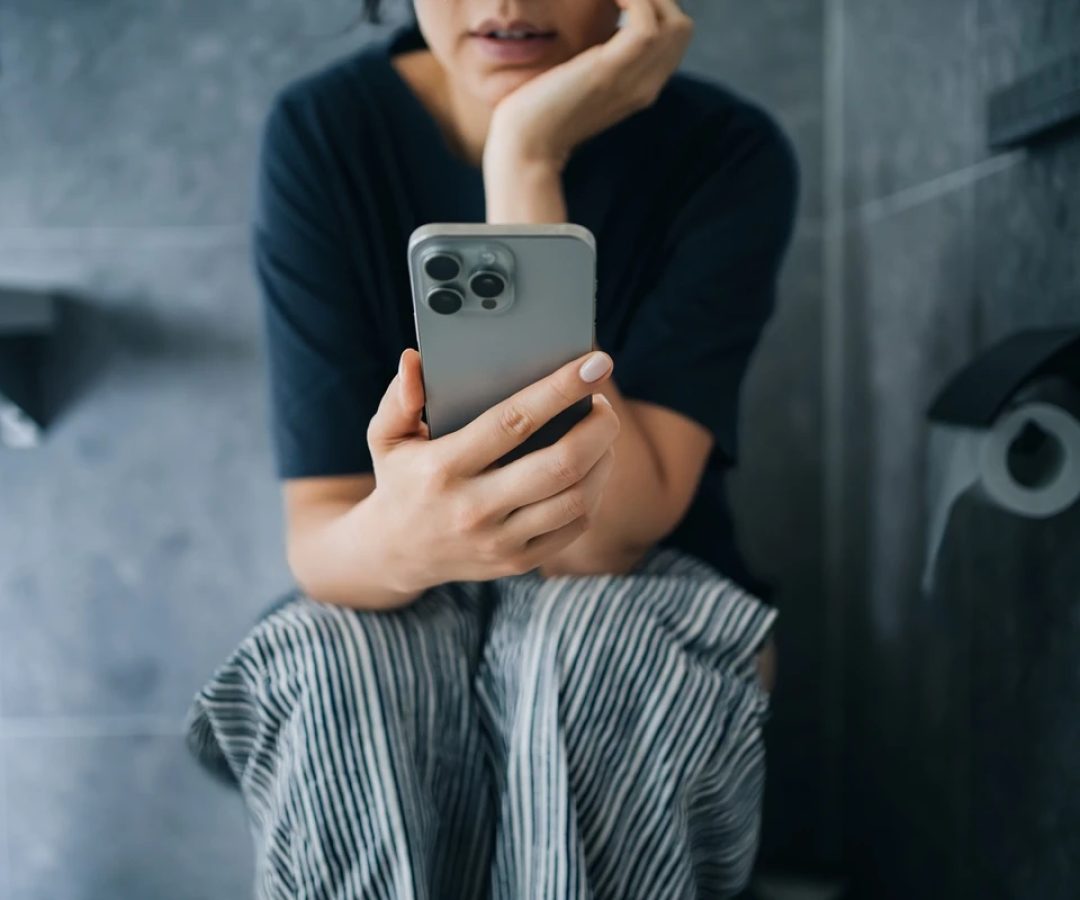 1 de 1 Mulher sentada em vaso sanitário mexendo no celular - Metrópoles - Foto: d3sign/ Getty I...