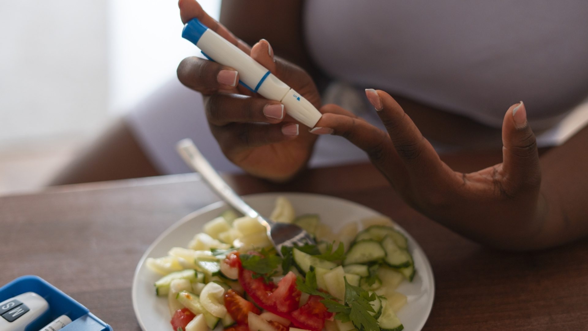 1 de 1 Foto colorida de mulher aplicando caneta de insulina com um prato de salada ao lado - Metr...