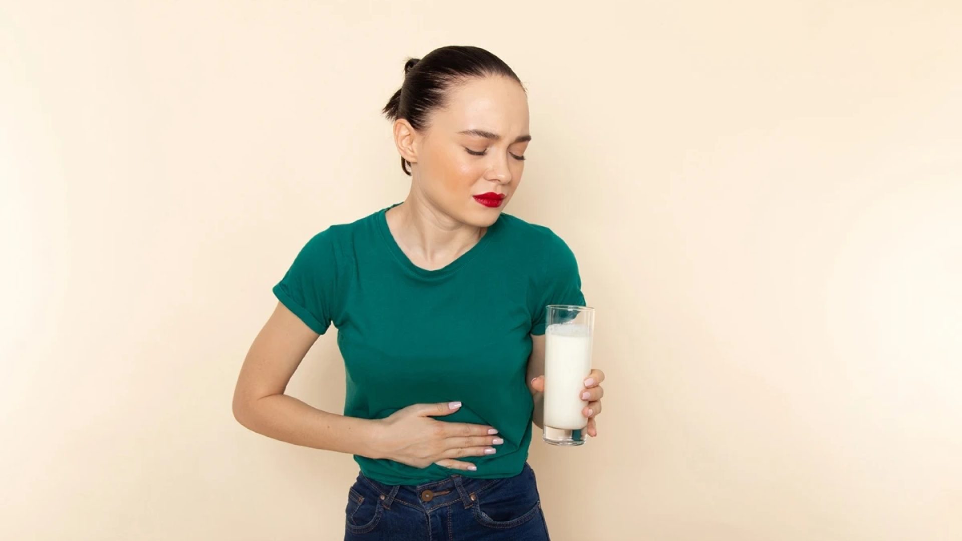 1 de 1 Mulher segurando um copo de leite e segurando a barriga- Metrópoles - Foto: Freepik