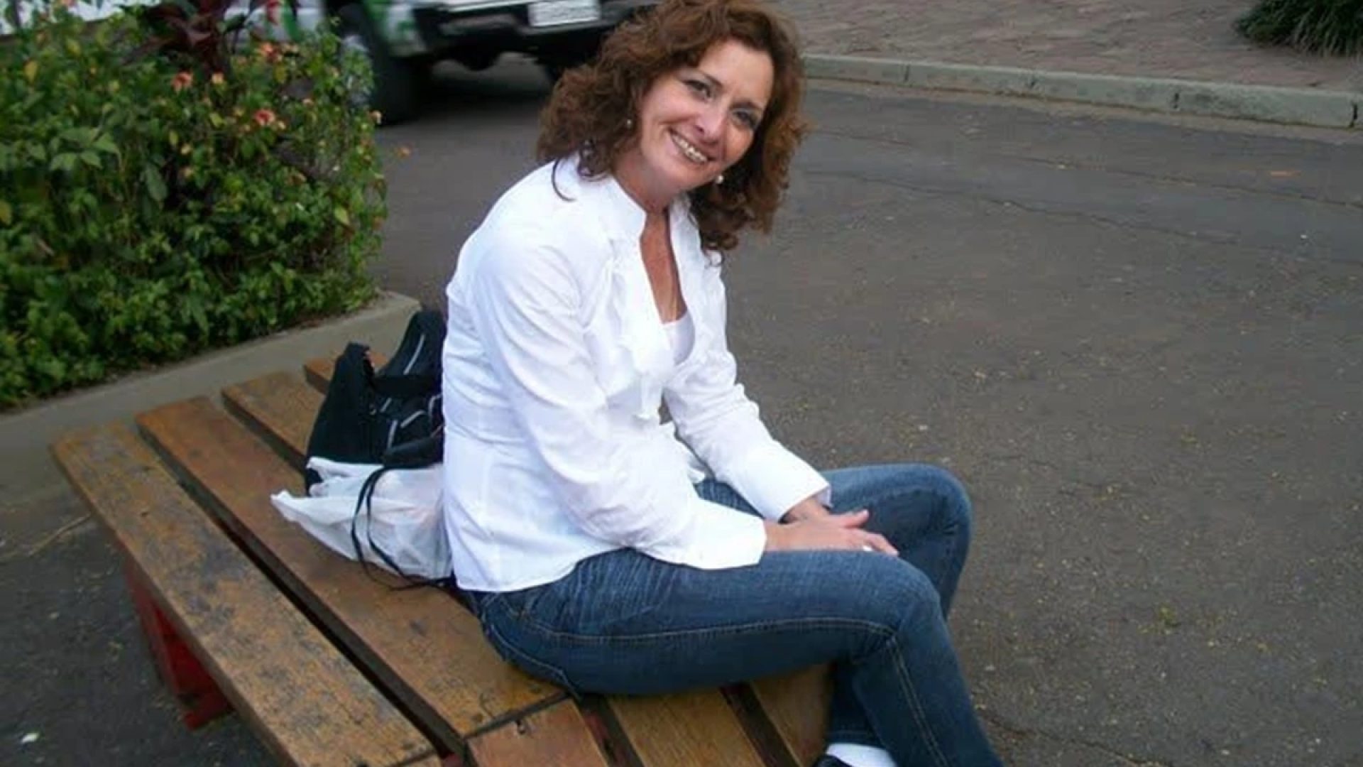 1 de 1 Foto colorida de mulher sentada em um banco na rua, sorrindo para foto - Metrópoles. - Fo...