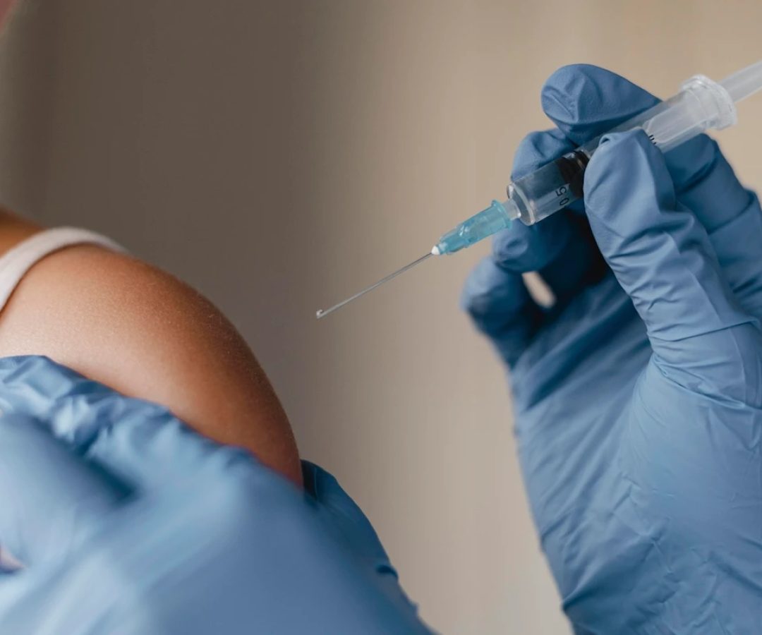 1 de 1 Close-up de um enfermeiro com luvas administrando vacina no braço de um pessoa. Metrópol...