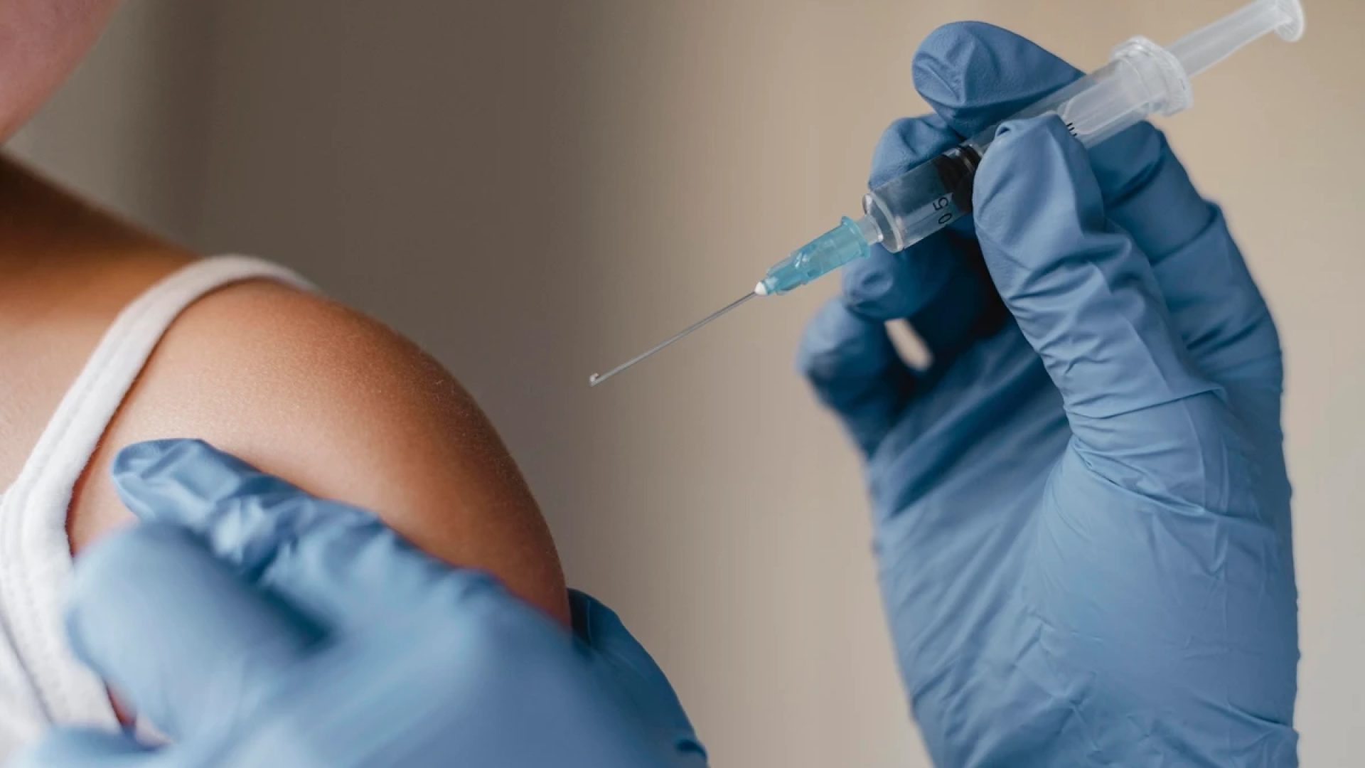 1 de 1 Close-up de um enfermeiro com luvas administrando vacina no braço de um pessoa. Metrópol...